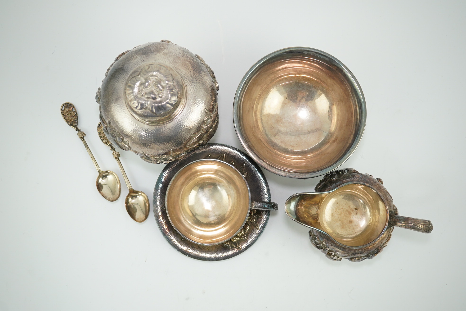 An early 20th century Japanese Meiji period planished silver matched? part tea set comprising a tea caddy with covers, sugar bowl, cream jug and tea cup and saucer